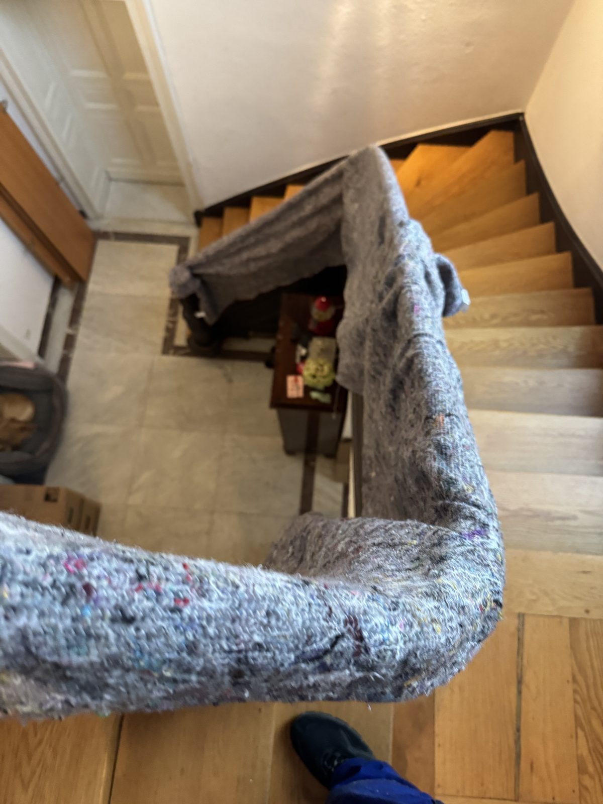 Das Geländer einer Treppe ist auf voller Länge mit einer Umzugsdecke umwickelt, damit nichts beschädigt wird.